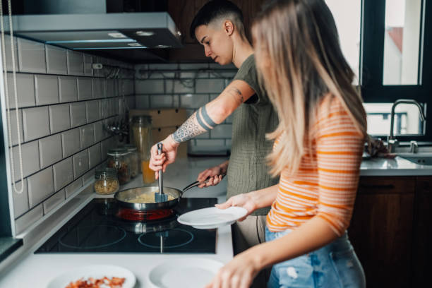 istock Lesbian couple cooking scrambled eggs in modern kitchen 2203331813