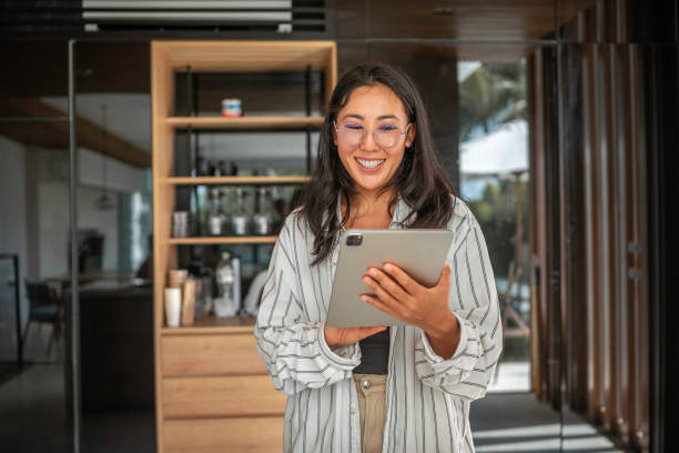 istock Cheerful Asian Woman Using Tablet Indoors 2203333129