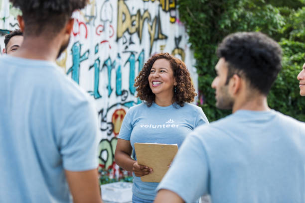 istock Smiling Volunteer Leader Talking with Team, Community Outreach 2203334111