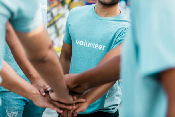 istock Multiracial Group of Volunteers Stacking Hands in Unity 2203334122