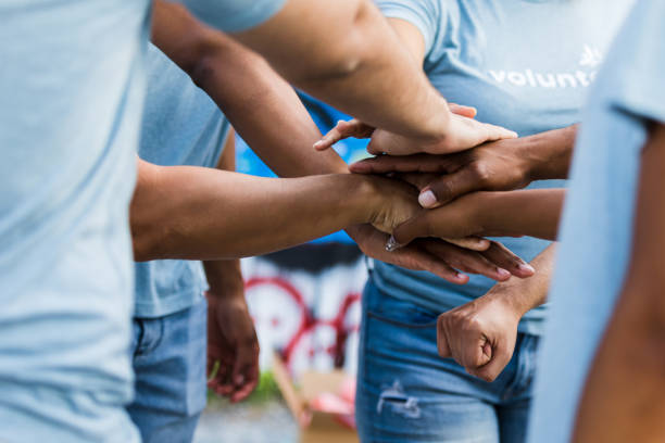 istock Multiracial Group of Volunteers Stacking Hands in Unity 2203334130
