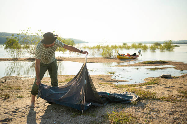 istock Man with Kayak Camping on Danube River Island. Adventure Trip 2203336254