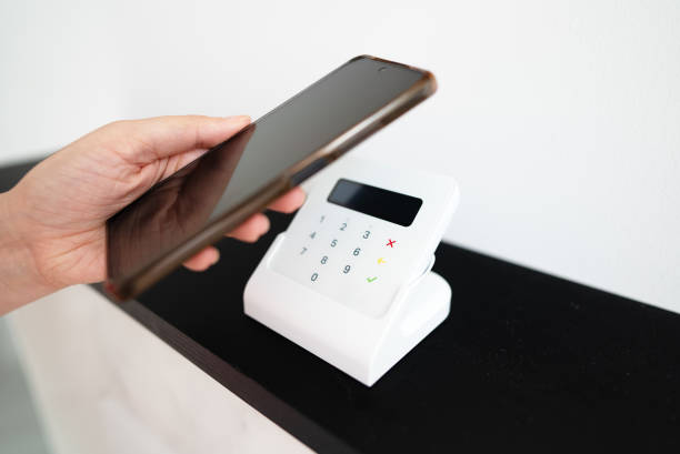 istock Woman's hand making a contactless payment with a phone. 2203342241