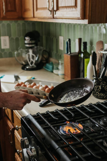 istock Man melts butter on a pan in a kitchen to cook eggs for breakfast 2203342375