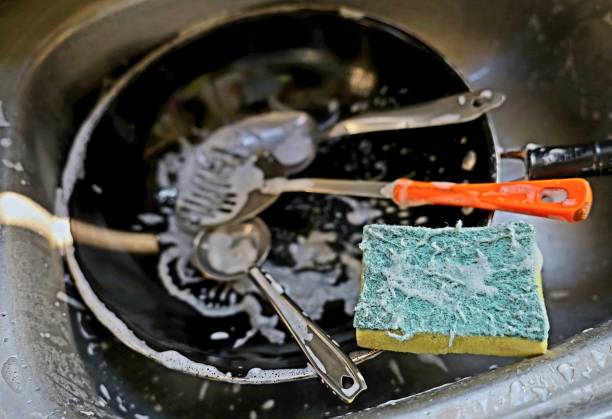 istock Using Sponge to clean kitchen utensils - food preparation. 2203343891