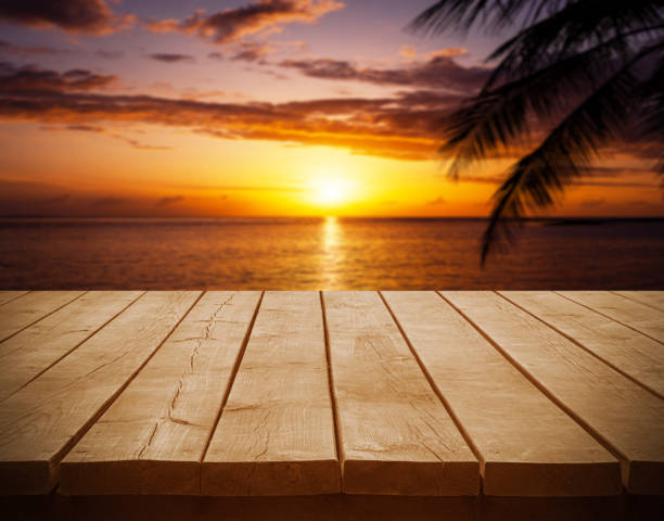 istock Empty wooden table top with tropical ocean sunset background 2203344734