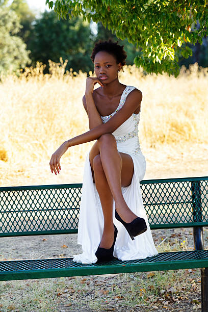 istock Attractive African American Teen Sitting On Bench Outdoors 2203345708