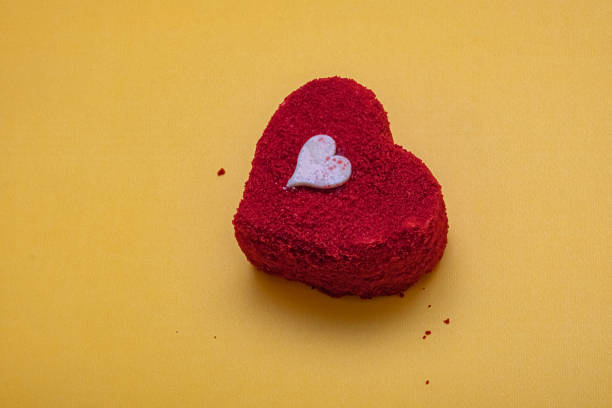 istock Beautifully crafted heart-shaped red velvet cake on textured surface. 2203345813