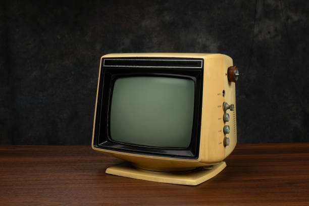istock Retro old yellow television receiver with blank screen on dark background. 2203348709