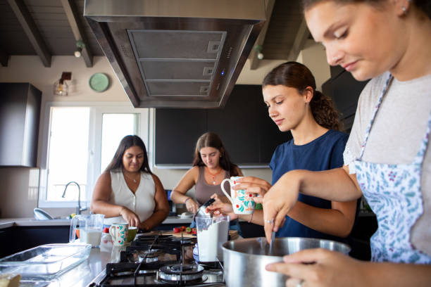 istock Happy young female friends preparing a cake in the kitchen 2203352093