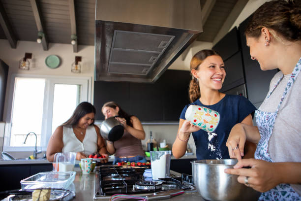 istock Happy young female friends preparing a cake in the kitchen 2203352102