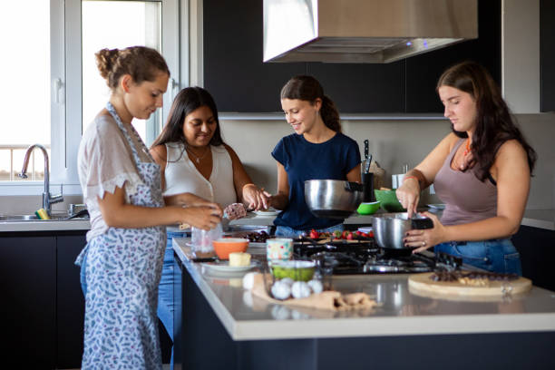 istock Happy young female friends preparing a cake in the kitchen 2203352364