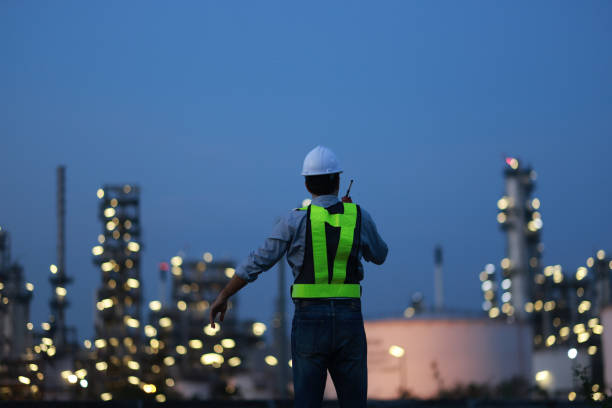 istock A chemical engineer is checking equipment and discussing work using a walkie-talkie at an oil refinery at night. A chemical engineer is inspecting machinery and talking about their work using a walkie-talkie at an oil refinery during the night. 2203352901