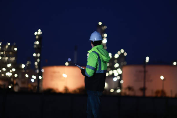 istock A chemical engineer is checking equipment and discussing work using a walkie-talkie at an oil refinery at night. A chemical engineer is inspecting machinery and talking about their work using a walkie-talkie at an oil refinery during the night. 2203352906