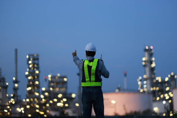 istock A chemical engineer is checking equipment and discussing work using a walkie-talkie at an oil refinery at night. A chemical engineer is inspecting machinery and talking about their work using a walkie-talkie at an oil refinery during the night. 2203352908