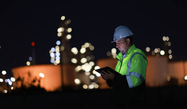 istock A chemical engineer is checking equipment and discussing work using a walkie-talkie at an oil refinery at night. A chemical engineer is inspecting machinery and talking about their work using a walkie-talkie at an oil refinery during the night. 2203352942