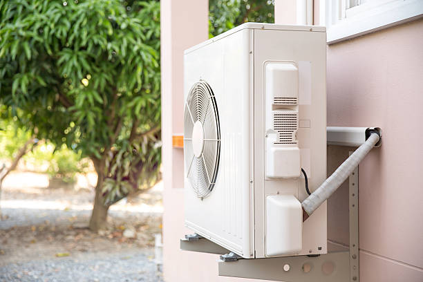 istock External split wall type of house air conditioner compressor unit installed on the outside of the building. 2203361034