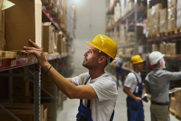 istock Warehouse worker working with cardboard box in storage room. 2203361051