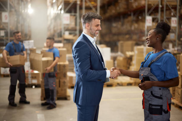 istock Happy inspector greeting with female manual worker in storage room. 2203361137