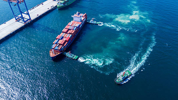 istock Tug boat pulling Cargo container ship go to international yard port. technology freight shipping with smart port. Cargo ship at logistic warehouse. 2203363059