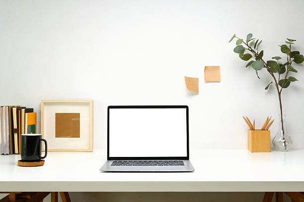 istock Laptop with blank screen, planner and a white coffee mug on white table, minimalist and modern workspace 2203363079