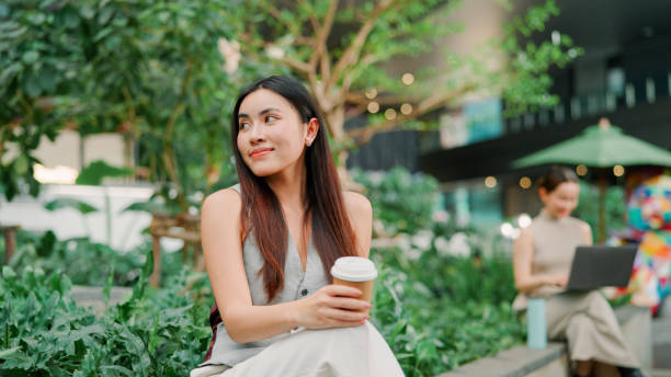 istock Asian woman holding coffee cup 2203363256