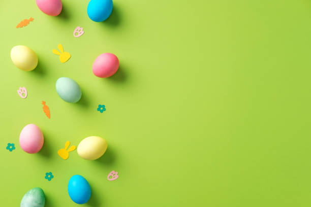istock Colorful Easter eggs and festive decorations on a vibrant green background. Flat lay, minimal style. 2203363482