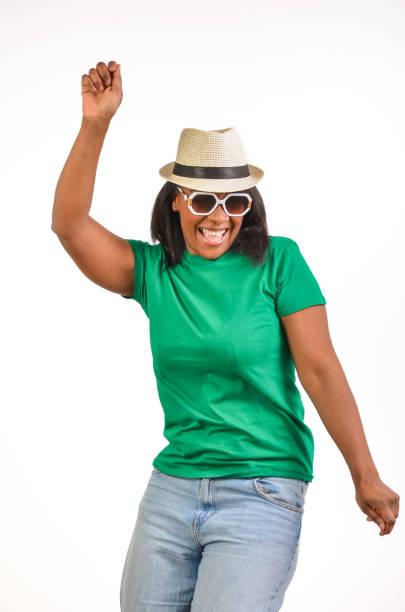 Young woman with multi-colored hairband and natural black hair looks at the camera with an expression of happy confidence.