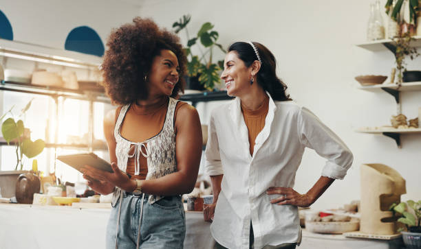 istock Workshop, women and startup with tablet for pottery, design inspiration or verification for order. Small business, smile and people as ceramist with scroll for clay ecommerce, track inventory or team 2203365316