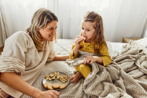 istock Happy single mother and daughter relaxing on a bed. 2203366259