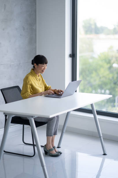 istock Successful woman smiling while using laptop at desk 2203366561