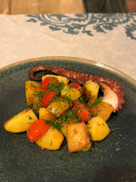 istock Grilled octopus with roasted potatoes, cherry tomatoes, and fresh dill on a plate. Suitable for food photography, restaurant menus, catering, and marketing 2203367561