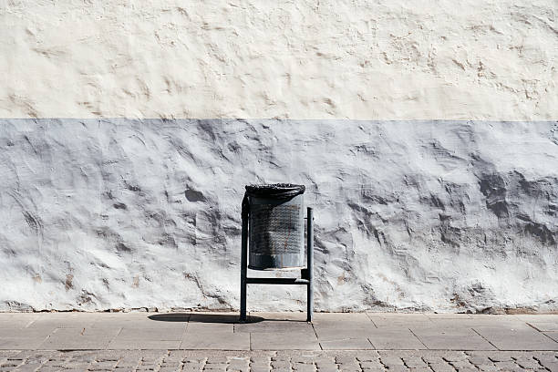 istock Simple Trash Bin in Front of a Textured Gray and White Wall During Daylight 2203367811
