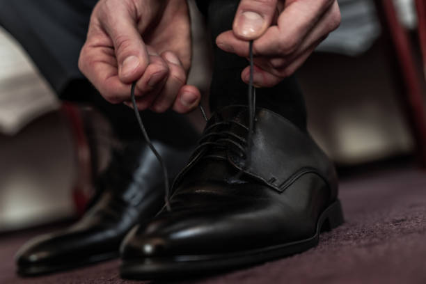 istock Man tying black formal shoes, getting ready 2203367840