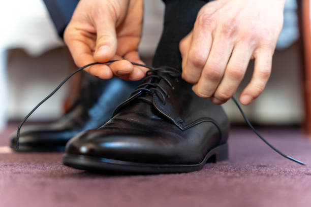 istock Man tying black leather formal shoes before event 2203367953