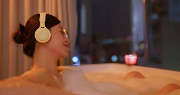 istock asian female soakbathe listen music 2203368907