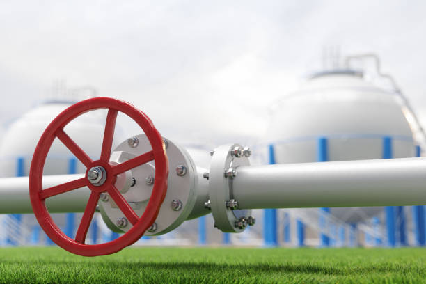 istock Close-up Of Pipe Line Valve On Grass With Storage Tanks Background 2203370038