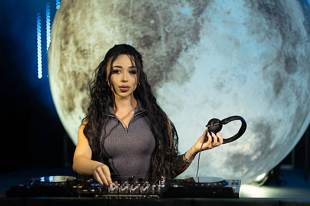istock Female DJ Freestyling a Live Set with Moon Backdrop at Night 2203370744