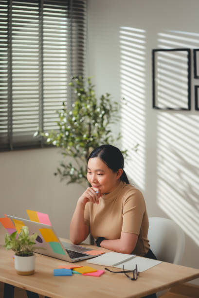 istock Asian woman enjoyed working and having new ideas taking notes sitting at home office. 2203371350