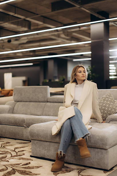 istock Stylish Woman Sitting on Sofa in Modern Interior Setting 2203372327