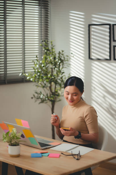 istock Asian woman enjoy with work and taking notes sitting at home office. 2203372538