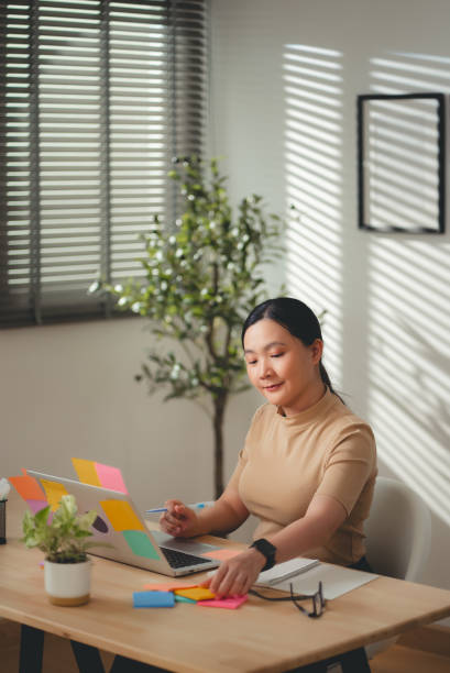 istock Asian woman enjoy with work and taking notes sitting at home office. 2203373083