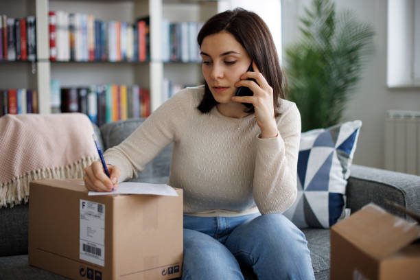 istock Female customer contacting the online retailer while filling out a return form 2203373360