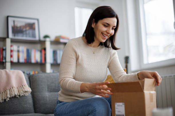 istock Woman enjoying unpacking her new purchase 2203373384