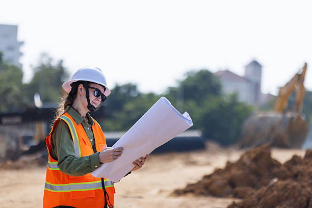 istock A female engineer  reviews blueprints at a construction site. 2203374480