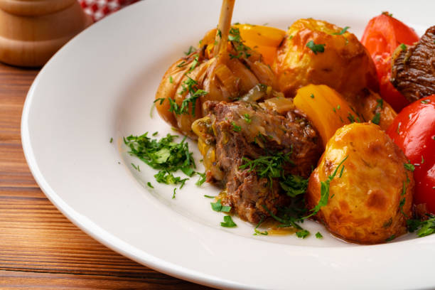 Beef meat stewed with potatoes on white plate, close up