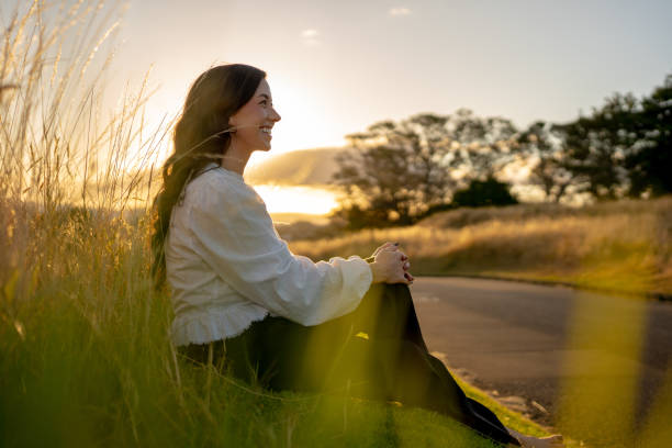 Confident Woman Sitting in Nature at Sunset