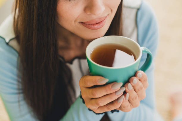 istock Young woman enjoying a warm beverage in a cozy home environment, highlighting relaxation, comfort, and casual lifestyle. 2203376330