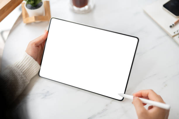 istock The left hand holding blank screen tablet and stylus pencil in right hand. Study or Working in cafe 2203376727