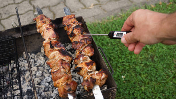 istock Measuring meat temperature while grilling meat in the backyard garden 2203379051